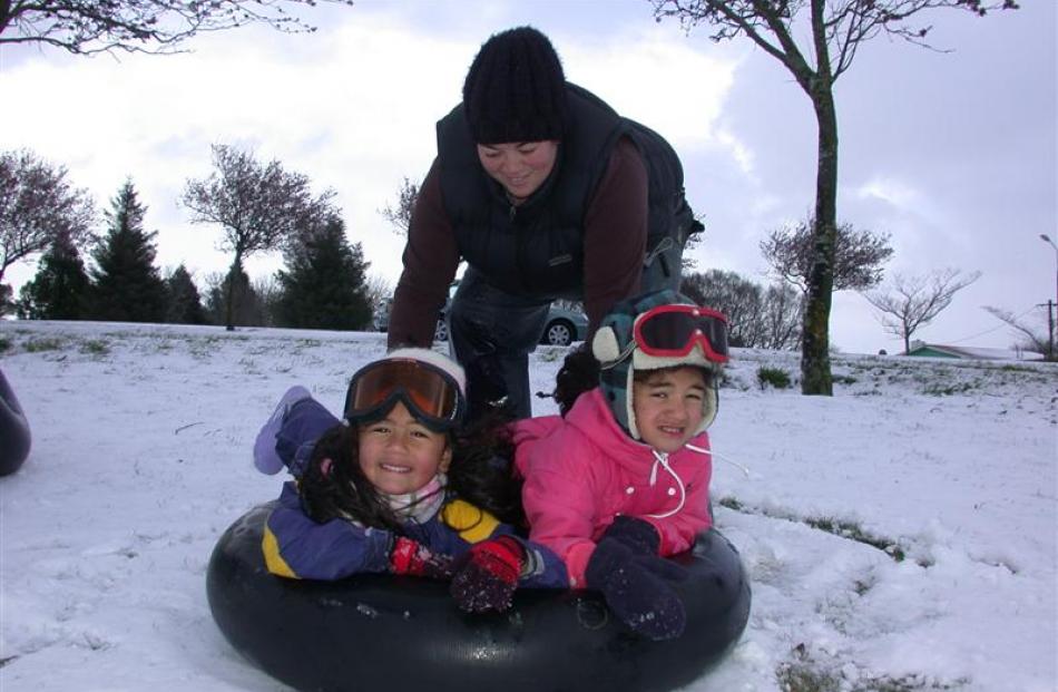 Jamaya Fisilau gives her 4-year-old twins Kyala (left) and Kalani a helping hand  snow tubing in...