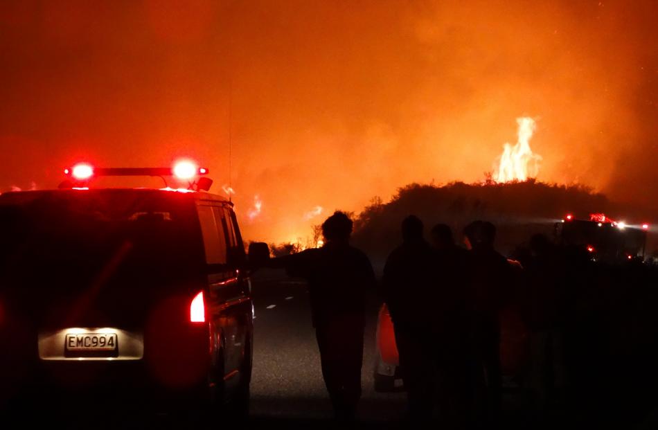 Fanned by variable and changeable winds, the fire lit up the night sky across a front of about...