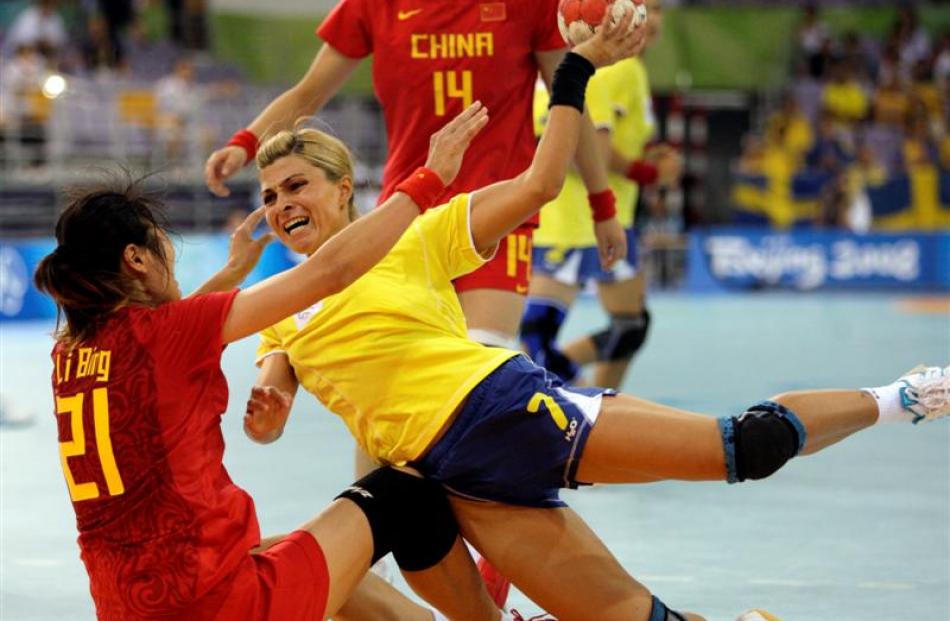 Romania's Adriana Olteanu, right, dives as she makes the shot around China's Li Bing during...