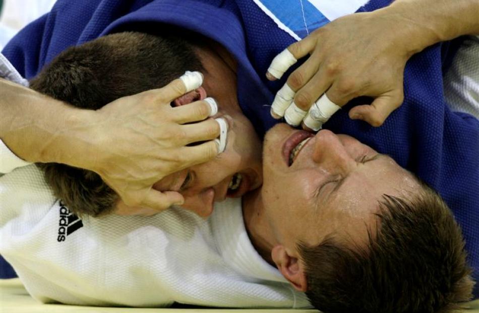 Kostantin Semenov, of Belarus, bottom, battles Dirk van Tichelt from Belgium in a -73 kg men's...