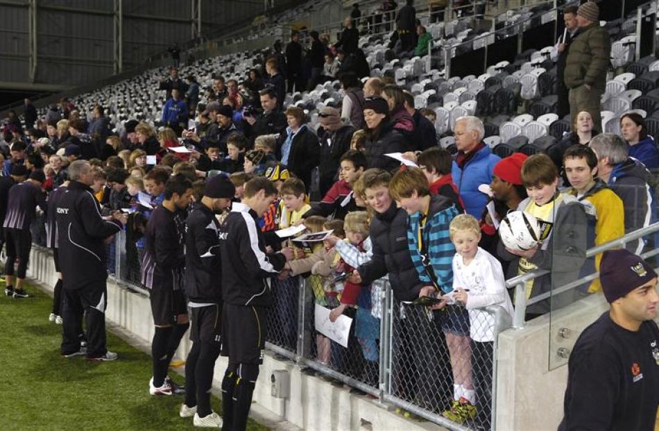 Fans throng the pitch sideline at the stadium to get Phoenix team members' signatures.