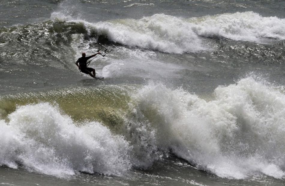 A kite-boarder takes advantage of high winds and surf from the effects of Hurricane Irene at...