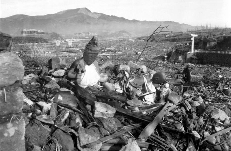 Battered religious figures stand watch on a hill above a tattered valley in Nagasaki, six weeks...