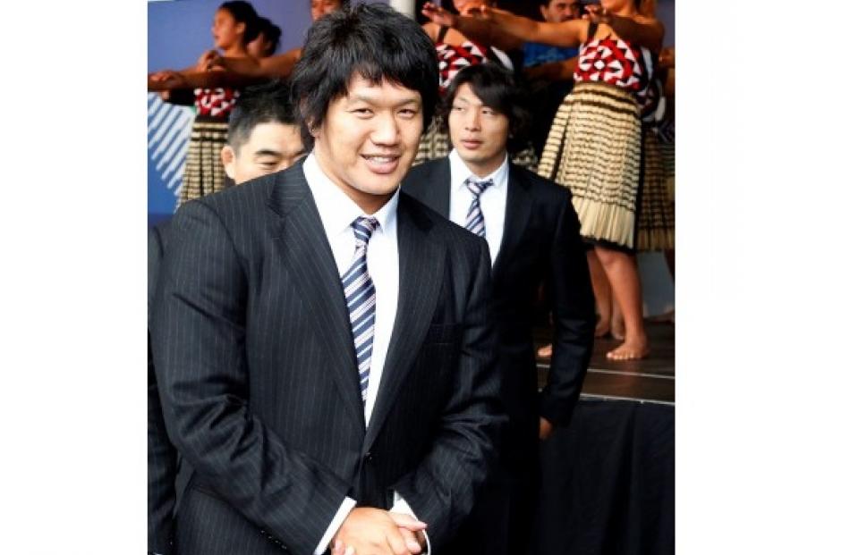 Japan captain Takashi Kikutani walks past Maori performers welcoming his team to New Zealand.