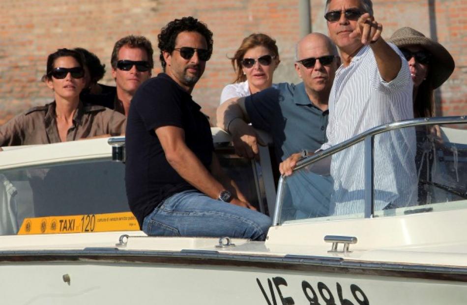 US actor George Clooney (2nd R) gestures as he arrives by speedboat in Venice for the 2011 Venice...