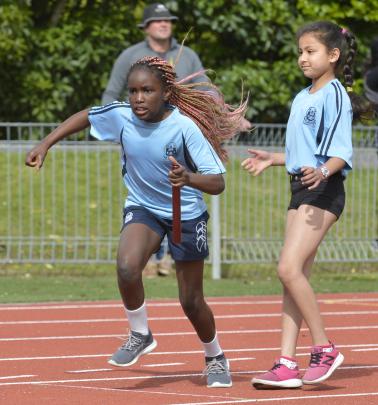 Esther Koudayah takes the baton from St Joseph's Cathedral School team-mate Muskan Uniyal in an...