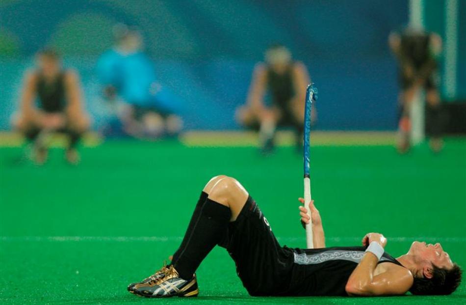 New Zealand's Simon Child lays on the field after their last second 1-0 loss to Spain during the...