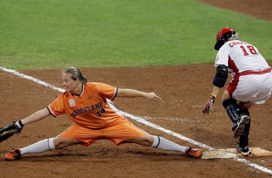 Canada's Erin Cumpstone, right, crosses first as Netherlands first baseman Kim Kluijskens...