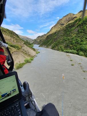 A helicopter crew surveys the flooded Shotover River. Photo: ORC