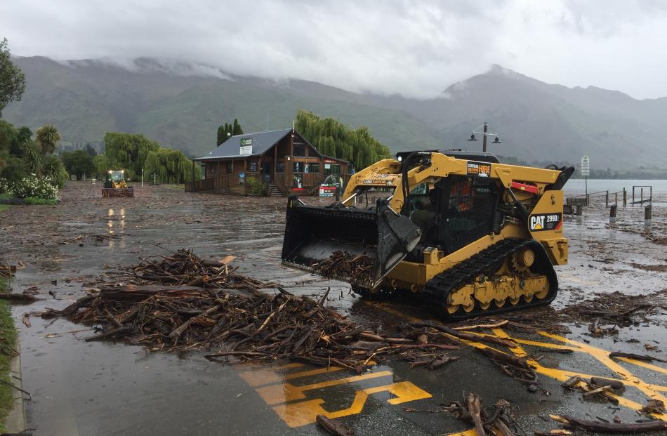 Heavy machinery clears debris from the Wanaka lakefront this afternoon. Photo: Gregor Richardson