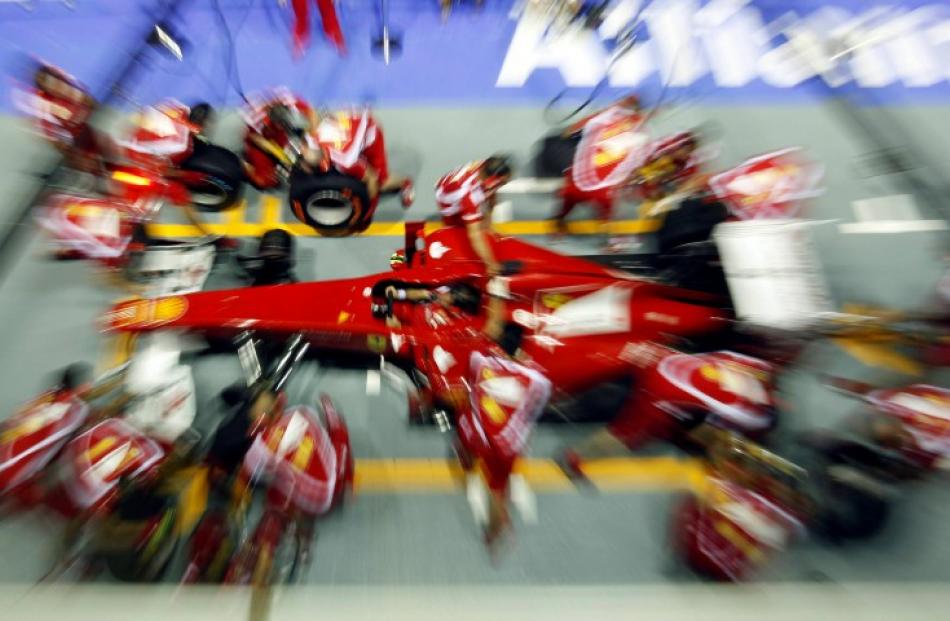Ferrari crew conduct a pit stop practice at the Marina Bay street circuit ahead of the Singapore...