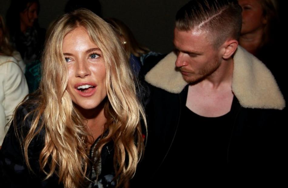 Actress Sienna Miller reacts after the presentation of the Matthew Williamson 2012 Spring/Summer...