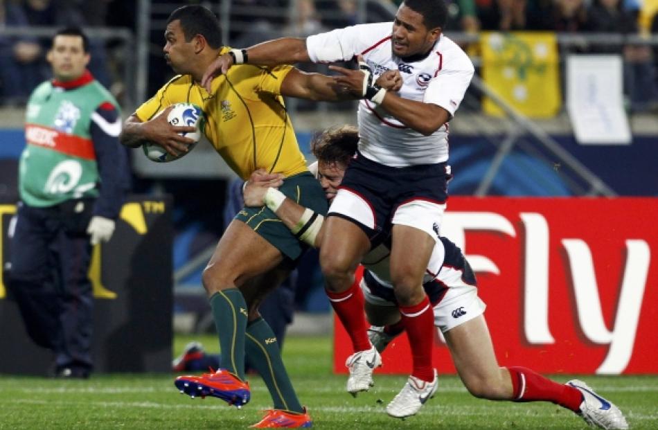 Blaine Scully (back) and Tai Enosa of the US tackle Australia Wallabies' Kurtley Beale during...