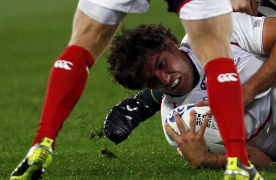 JJ Gagiano of the US moves the ball out as he is tackled during their Rugby World Cup Pool C...