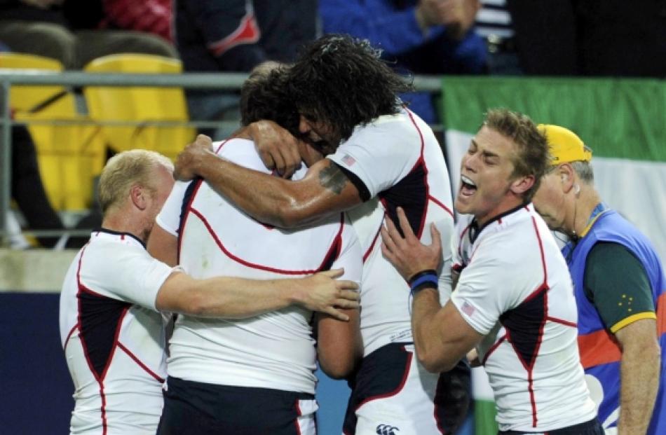 JJ Gagiano (second from left) of the US celebrates scoring a try with teammates during their...