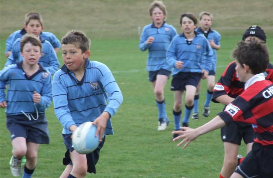 Wakatipu Under-11 player Oliver Price (11), supported by Troy Anstiss (11), makes the pass in...
