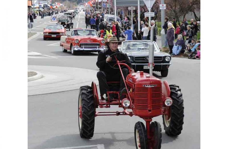 Alan McCrostie leads a parade of classic cars down Centennial Avenue.