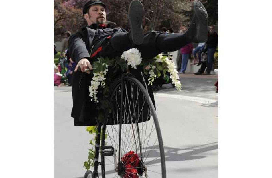 Shane Price glides down Centennial Avenue on his Penny Farthing.
