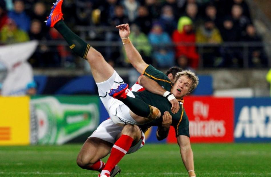 Wales' Jamie Roberts tackles South Africa's Jean de Villiers.