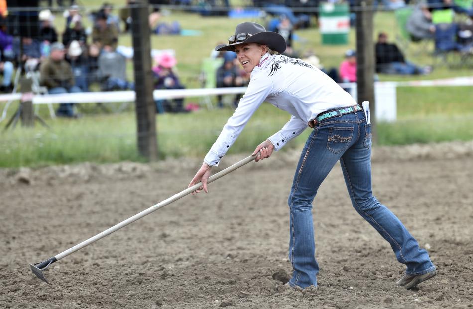 Annabelle Wiggins, of Ashburton, rakes the rodeo ground surface.
