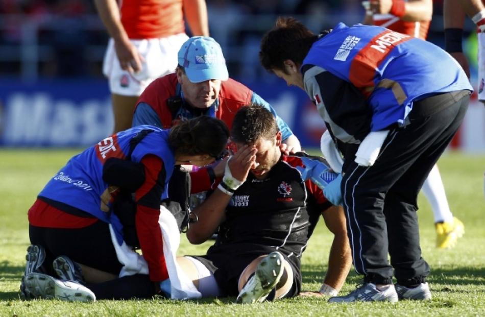 Canada's James Pritchard receives medical assistance after colliding with Japan's Ryan Nicholas...