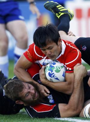Canada's Jebb Sinclair (bottom) pushes Japan's Hirotoki Onozawa out of touch during their Rugby...
