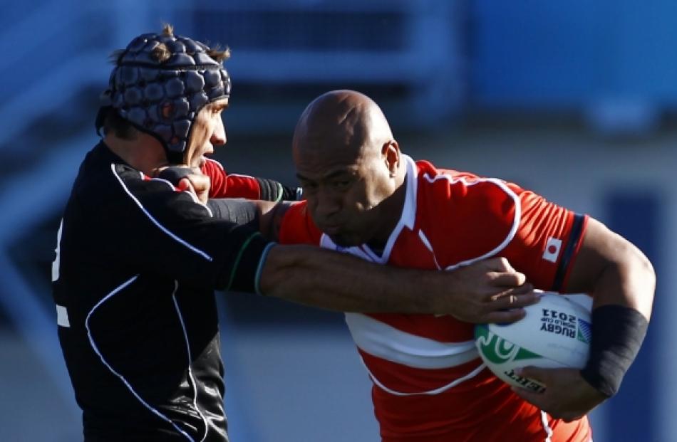 Canada's Ryan Smith (left) tackles Japan's Alisi Tupuailai during their Rugby World Cup Pool A...