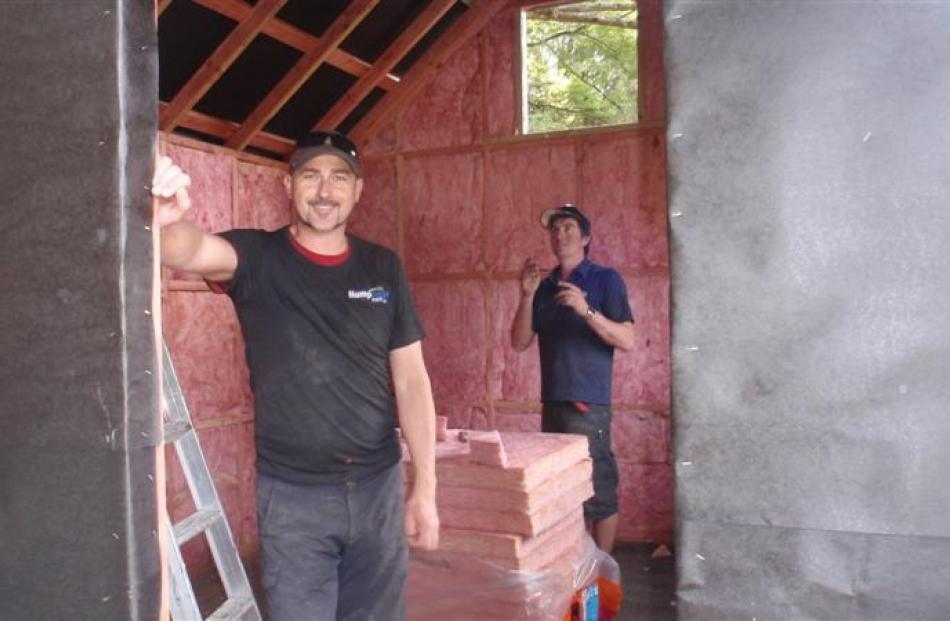 Paradise Trust co-manager Daman Groshinski (left) and Mike Kingan, of Wanaka, install insulation...