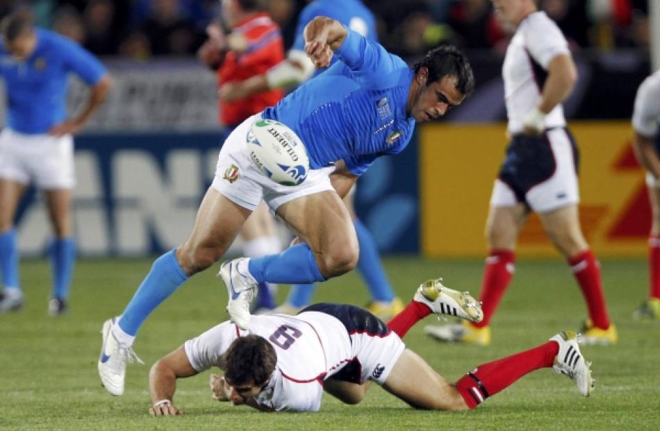 Italy's Gonzalo Canale jumps over Mike Petri (on ground) of the US as he fumbles the ball during...