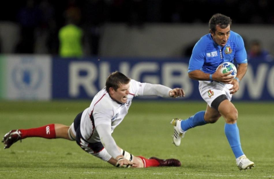 Italy's Luciano Orquera (right) shakes off a tackle by Hayden Smith of the US during their Rugby...