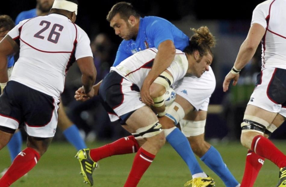 Italy's Quintin Geldenhuys tackles US captain Todd Clever (centre) during their Rugby World Cup...