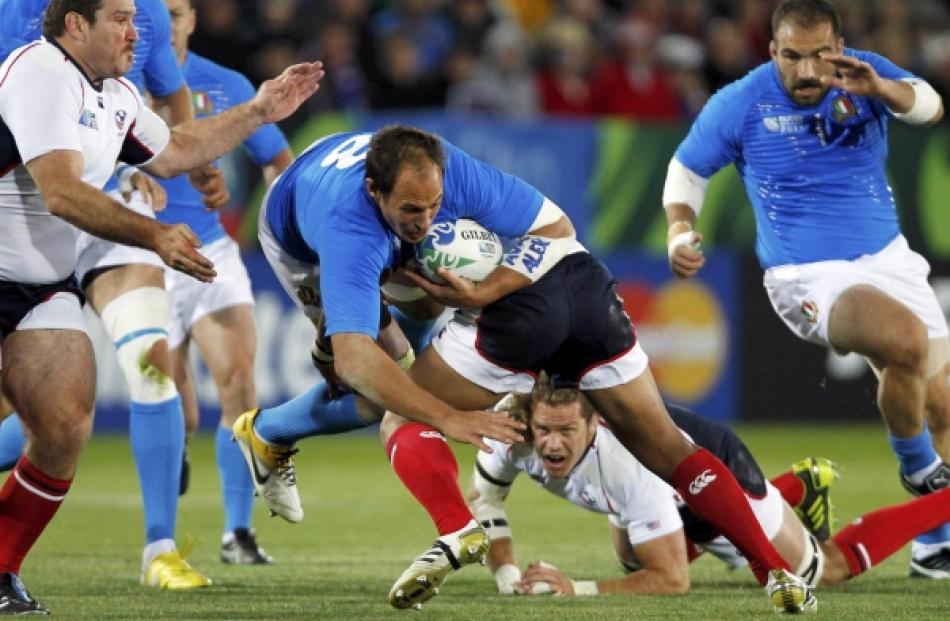 Roland Suniula (centre) of the US tackles Italy captain Sergio Parisse during their Rugby World...