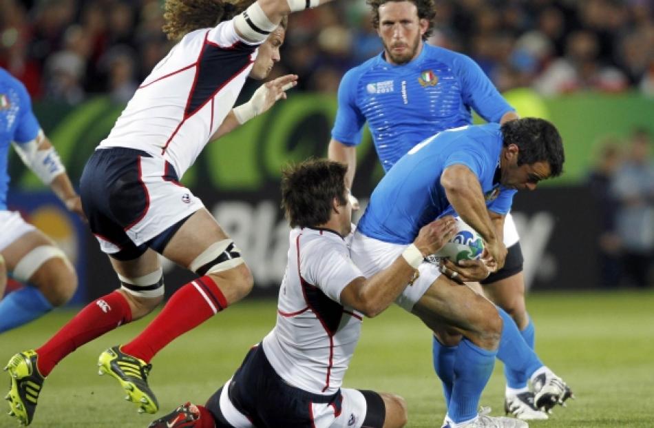 Roland Suniula (centre) of the US tackles Italy's Gonzalo Canale (R) as captain Todd Clever...
