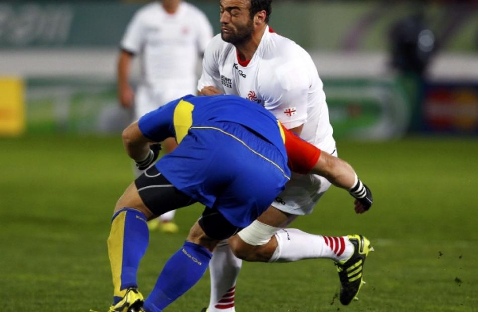 Romania captain Marius Tincu (front) tackles Georgia's Mamuka Gorgodze during their Rugby World...