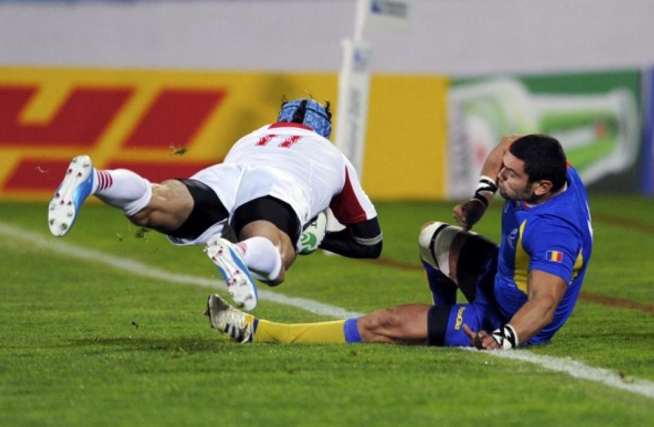 Romania's Stefan Eugen Ciuntu (right) tackles Georgia's Alexander Todua during their Rugby World...