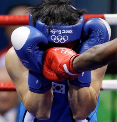 Kim Jungjoo of South Korea takes a punch from John Jackson of Virgin Islands, during a men's...