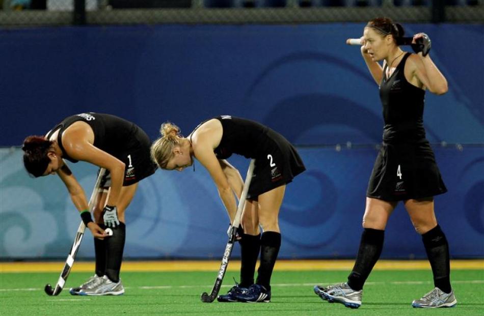 New Zealand's Kayla Sharland, left, Emily Naylor, center, and Kate Saunders react after losing 2...