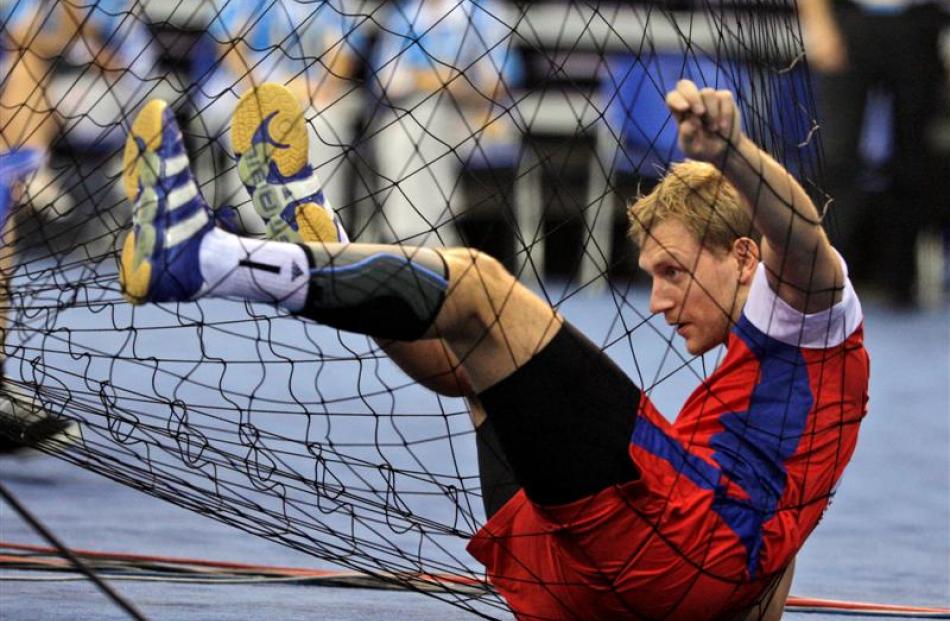 Russia's Vasily Filippov sits in the net after crashing into it  during a men's  preliminary...