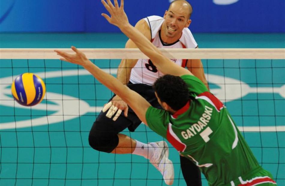 USA's  William Priddy spikes the ball through Krasimir Gaydarski of Bulgaria.  (AP Photo/Andy Wong)