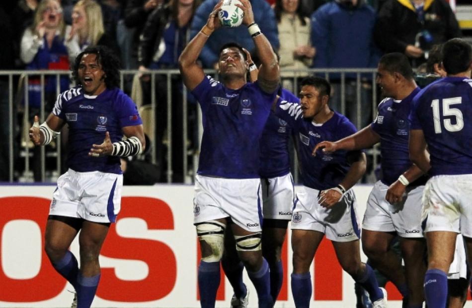Samoa players celebrate a try during their Rugby World Cup Pool D match against South Africa...
