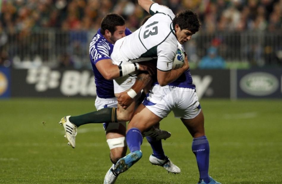 Samoa's Kane Thompson (left) tackle South Africa Springboks' Jaque Fourie (C) during their Rugby...