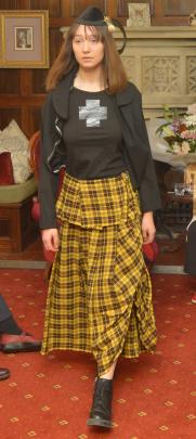 Jessica Clarke  showcases a Dr Margo Barton hat accompanied by a Commes des Garcon yellow tartan...