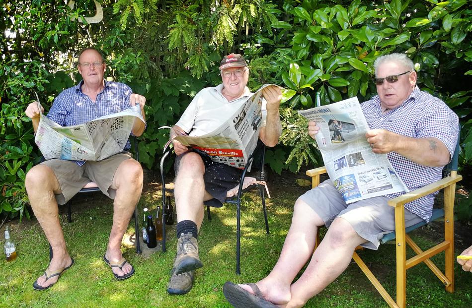 The lawns mowed and drinks poured, Geoff Davis, of Palmerston, John Rawson, of Oamaru, and Trevor Young, of Cromwell, take the chance to read the Otago Daily Times delivered to Te Anau. Photo: Lois Davis