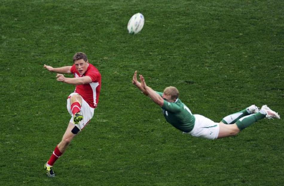 Ireland's Keith Earls (right) attempts to block a kick by Wales' Rhys Priestland during their...