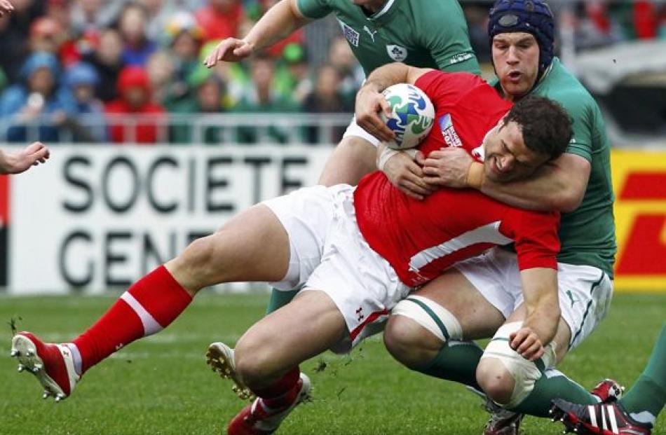 Ireland's Sean O'Brien (right) tackles Wales' Jamie Roberts during their Rugby World Cup quarter...