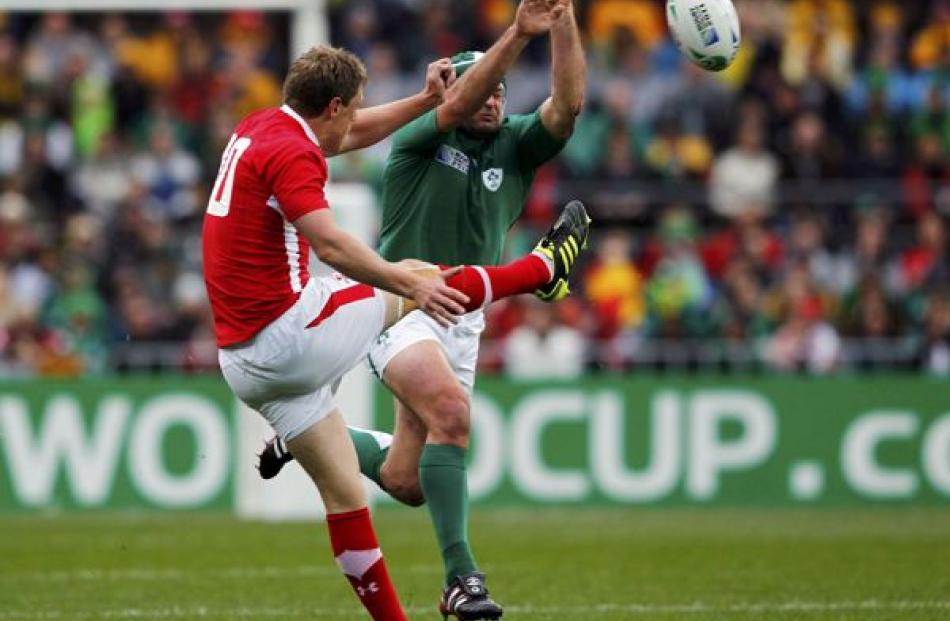 Ireland's Rory Best (right) attempts to smother a kick by Wales' Rhys Priestland during their...
