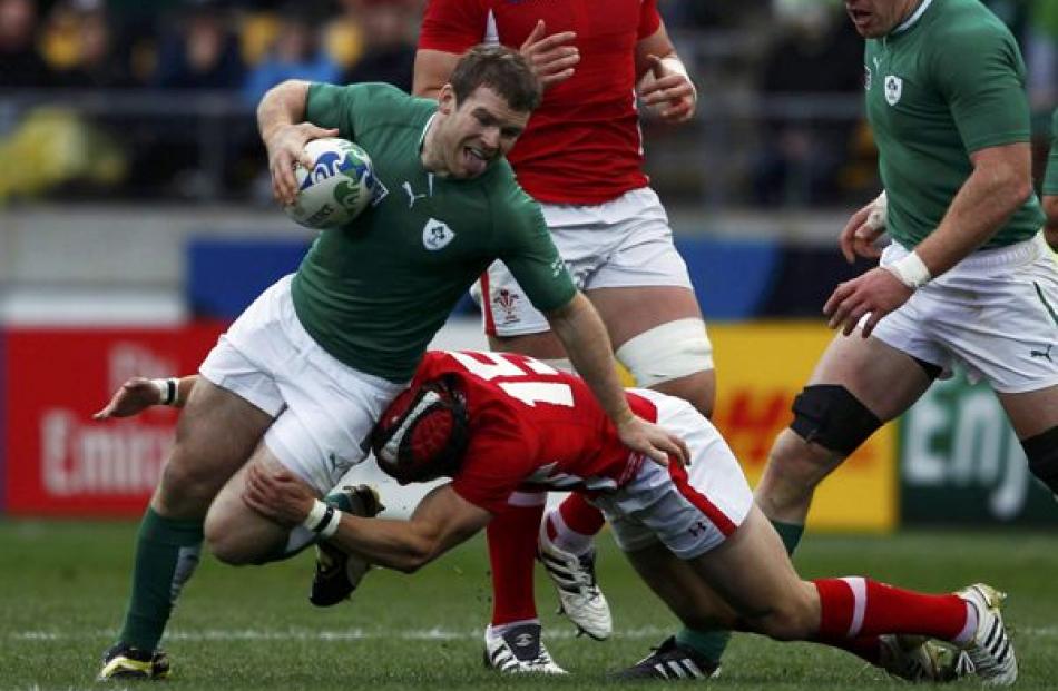Wales' Leigh Halfpenny tackles Ireland's Gordon D'Arcy (left) during their Rugby World Cup...