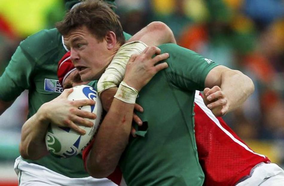 Wales' Alun Wyn Jones tackles Ireland captain Brian O'Driscoll (front) during their Rugby World...