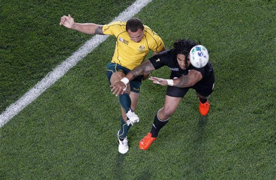 Quade Cooper kicks the ball clear as Ma'a Nonu attempts to charge it down. (AP Photo/Dita Alangkara)