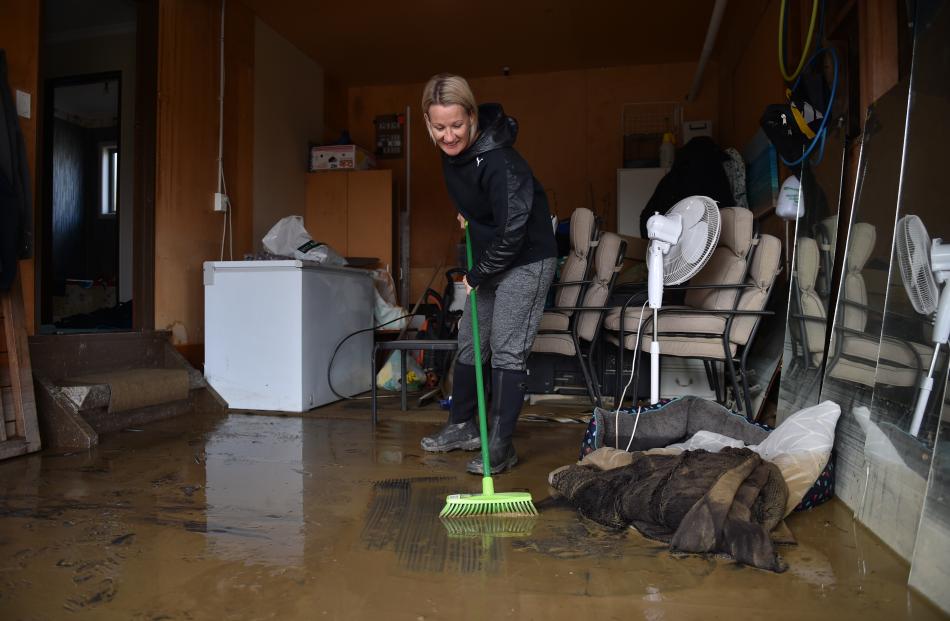Karla Graves, of East Gore, gets down to the task of cleaning up her garage after floodwater...